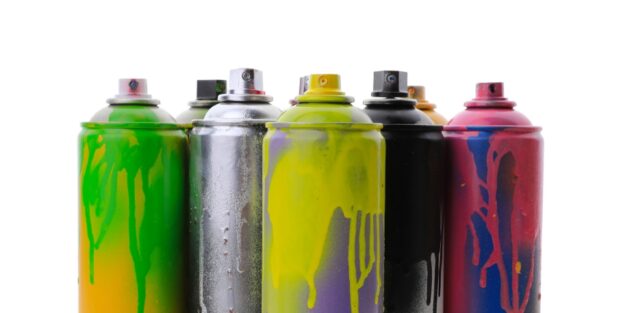 spray paint dirty spray paint cans lined up in front of a white background