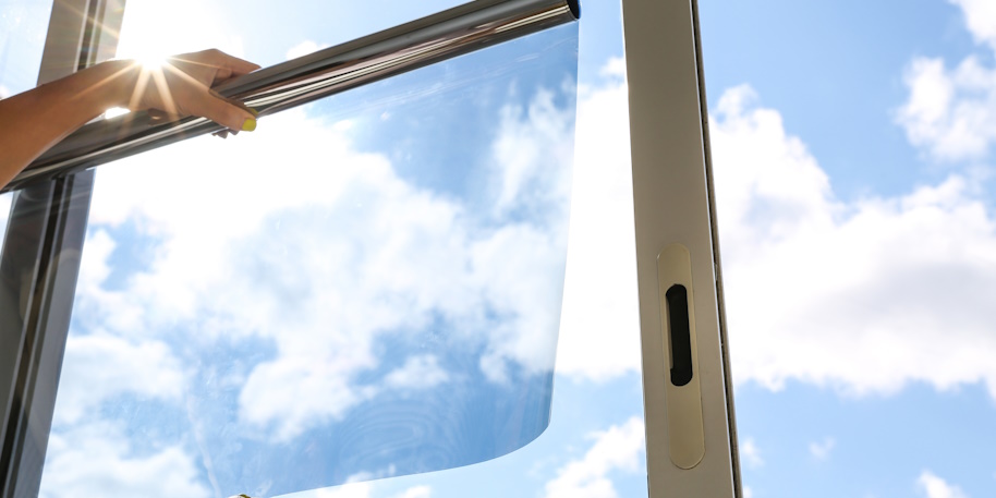 window tint being held up in front of a window