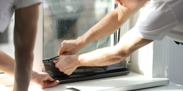 two men applying residential window tinting two men applying residential window tinting