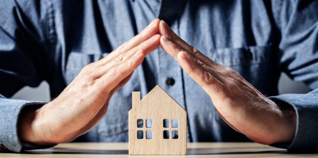 hands around wooden home cutout hands around wooden home cutout