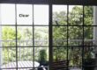 A window partially covered with window film installed by Energy Solutions Window Tinting, showing a clear difference between the tinted and untinted glass.