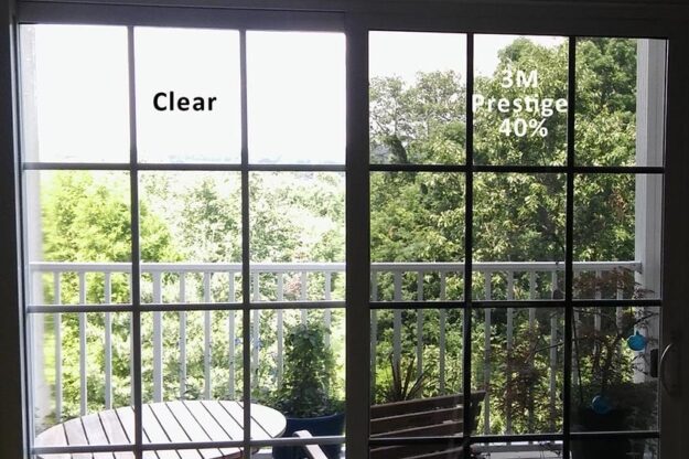 A window partially covered with window film installed by Energy Solutions Window Tinting, showing a clear difference between the tinted and untinted glass.