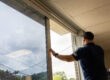 Professional installer applying window tint to a storefront window to reduce heat, glare, and fading.