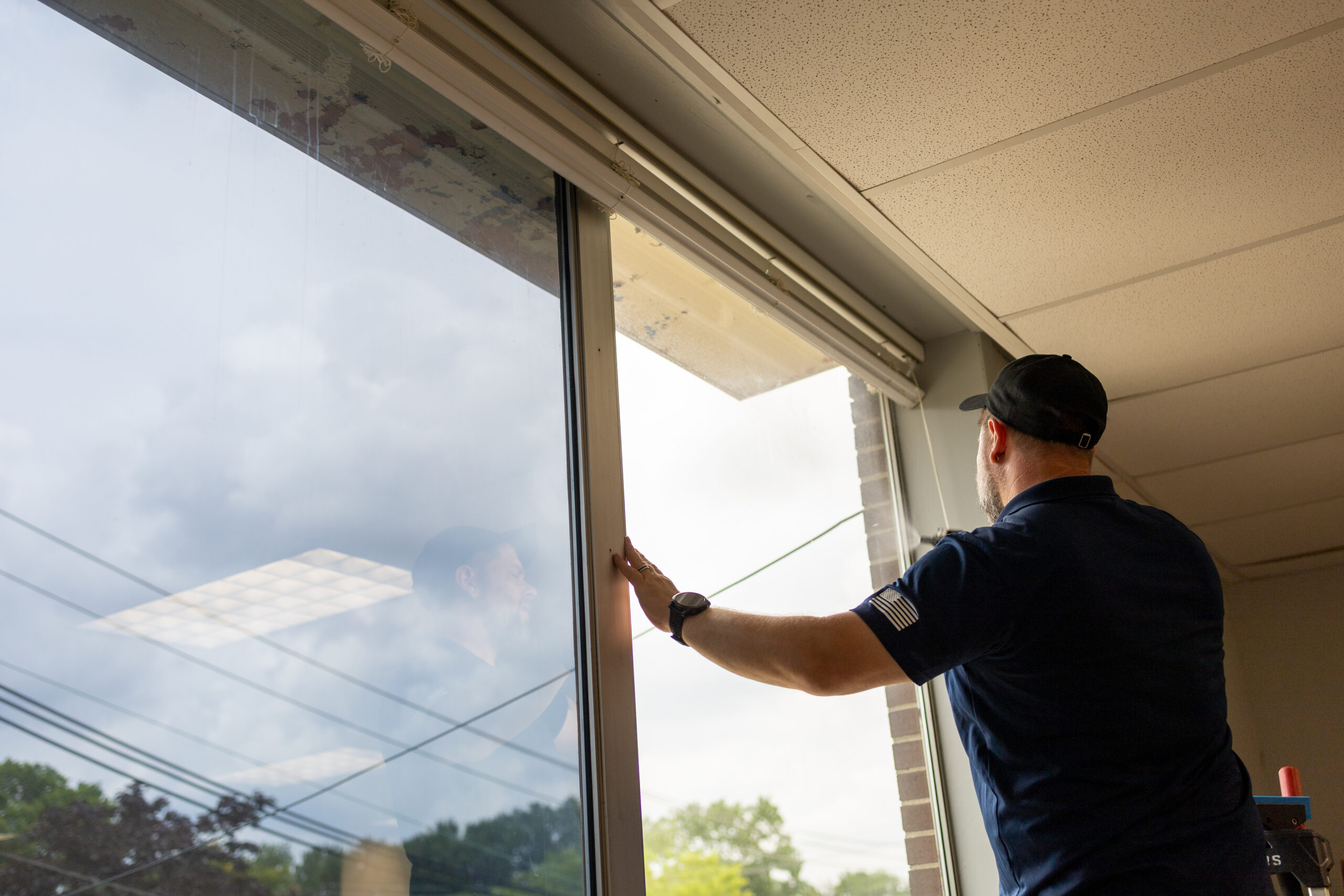 Professional installer applying window tint to a storefront window to reduce heat, glare, and fading.